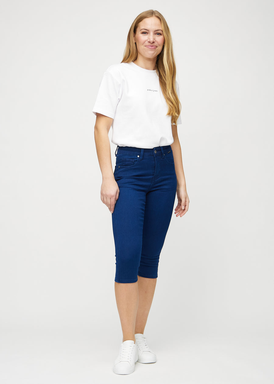 Skinny-capris til kvinner i mørkeblått jeansstoff, fargen Royals. Helhetsbilde av en modell med capris på.