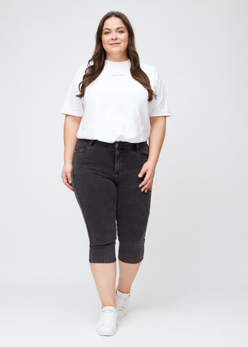 Skinny-capris til kvinner i mørkegrå denim, fargen Shadows. Helhetsbilde av en plus size-modell med capris på.