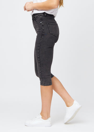 Kvinne i mørkegrå Shadows denimcapris i skinny fit, sett fra siden.
