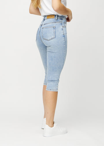 Skinny-capris til kvinner i lyseblå denim, fargen Waves. Sett bakfra på en modell, med fokus på passform og baklommer.