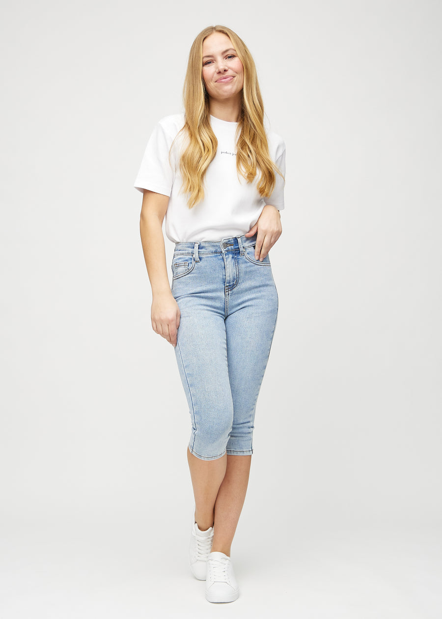 Skinny-capris til kvinner i lyseblå denim, fargen Waves. Helhetsbilde av en modell med capris på.