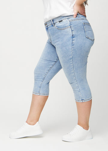 Skinny-capris til kvinner i lyseblå denim, fargen Waves. Sett fra siden på en plus size-modell, med tettsittende passform.