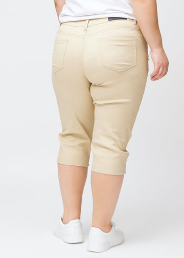 Slim-capris til kvinner i beige jeansstoff, fargen Gazelles. Sett bakfra på en plus size-modell, med fokus på passform, lengde og baklommer.
