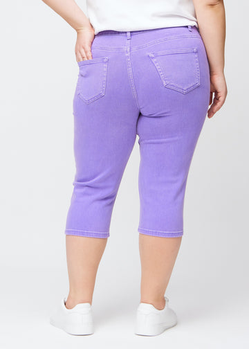Slim-capris til kvinner i pastellilla jeansstoff, fargen Lavenders. Sett bakfra på en plus size-modell, med fokus på passform, lengde og baklommer.