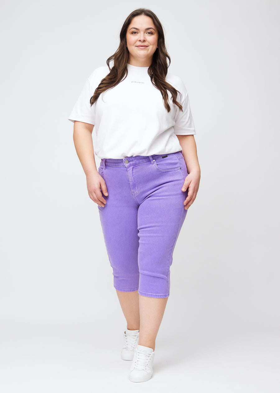 Slim-capris til kvinner i pastellilla jeansstoff, fargen Lavenders. Helhetsbilde av en plus size-modell med slim-capris.
