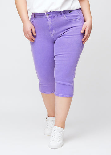 Slim-capris til kvinner i pastellilla jeansstoff, fargen Lavenders. Sett forfra på en plus size-modell, med figursydd passform til rett under kneet.