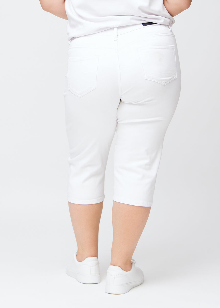 Slim-capris til kvinner i hvitt jeansstoff, fargen Marguerites. Sett bakfra på en plus size-modell, med fokus på passform, lengde og baklommer.