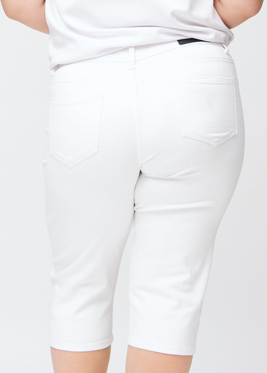 Slim-capris til kvinner i hvitt jeansstoff, fargen Marguerites. Nærbilde bakfra på en plus size-modell, med fokus på baklommer og sømmer.