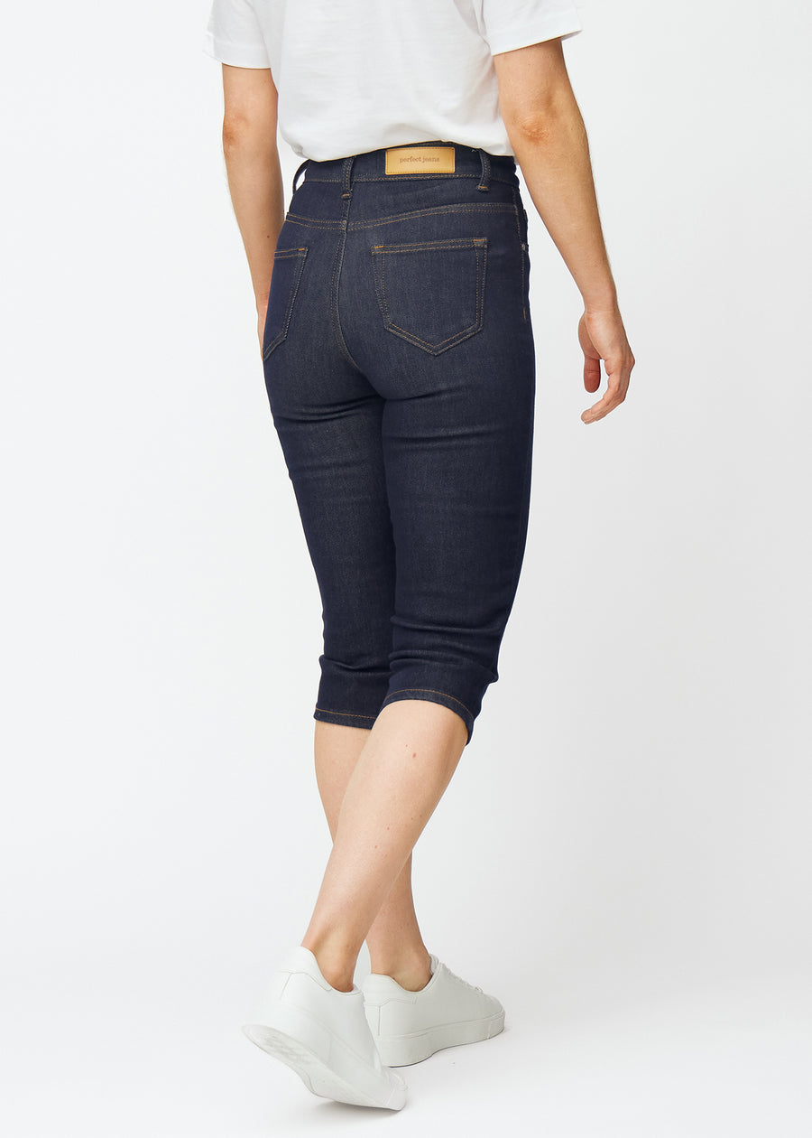 Dyp mørkeblå denim capris til dame i fargen Midnights sett bakfra.