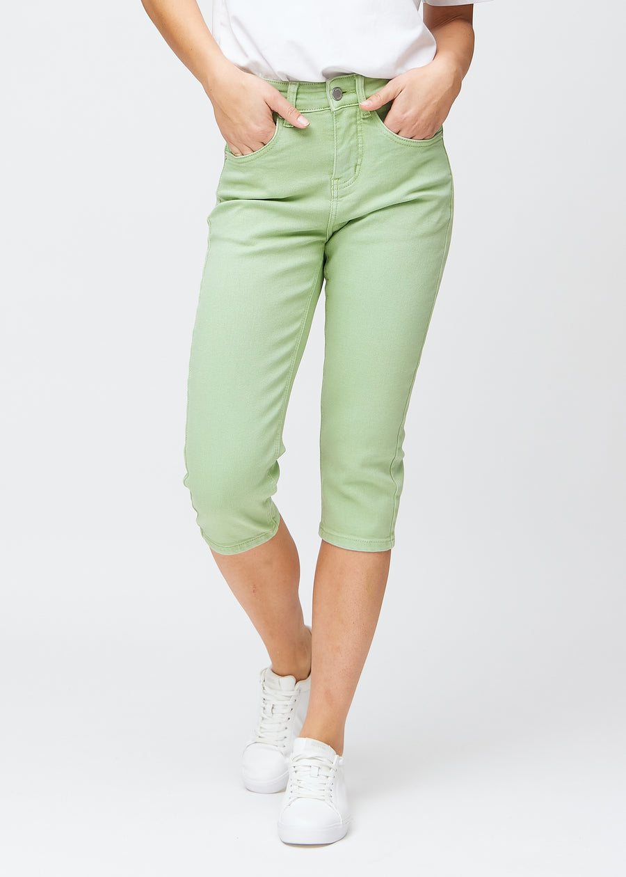 Slim-capris til kvinner i pastelllysegrønt jeansstoff, fargen Mints. Sett forfra på en modell, med figursydd passform til rett under kneet.