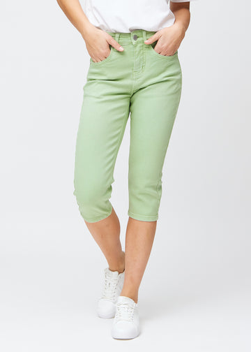 Slim-capris til kvinner i pastelllysegrønt jeansstoff, fargen Mints. Sett forfra på en modell, med figursydd passform til rett under kneet.