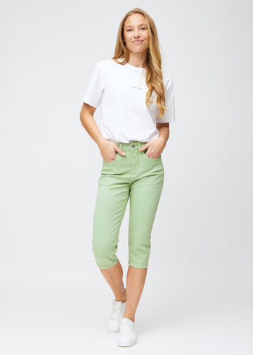Slim-capris til kvinner i pastelllysegrønt jeansstoff, fargen Mints. Helhetsbilde av en modell med slim-capris.