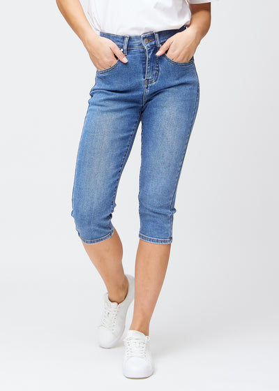 Slim-capris til kvinner i blå denim, fargen Rivers. Sett forfra på en modell, med figursydd passform til rett under kneet.
