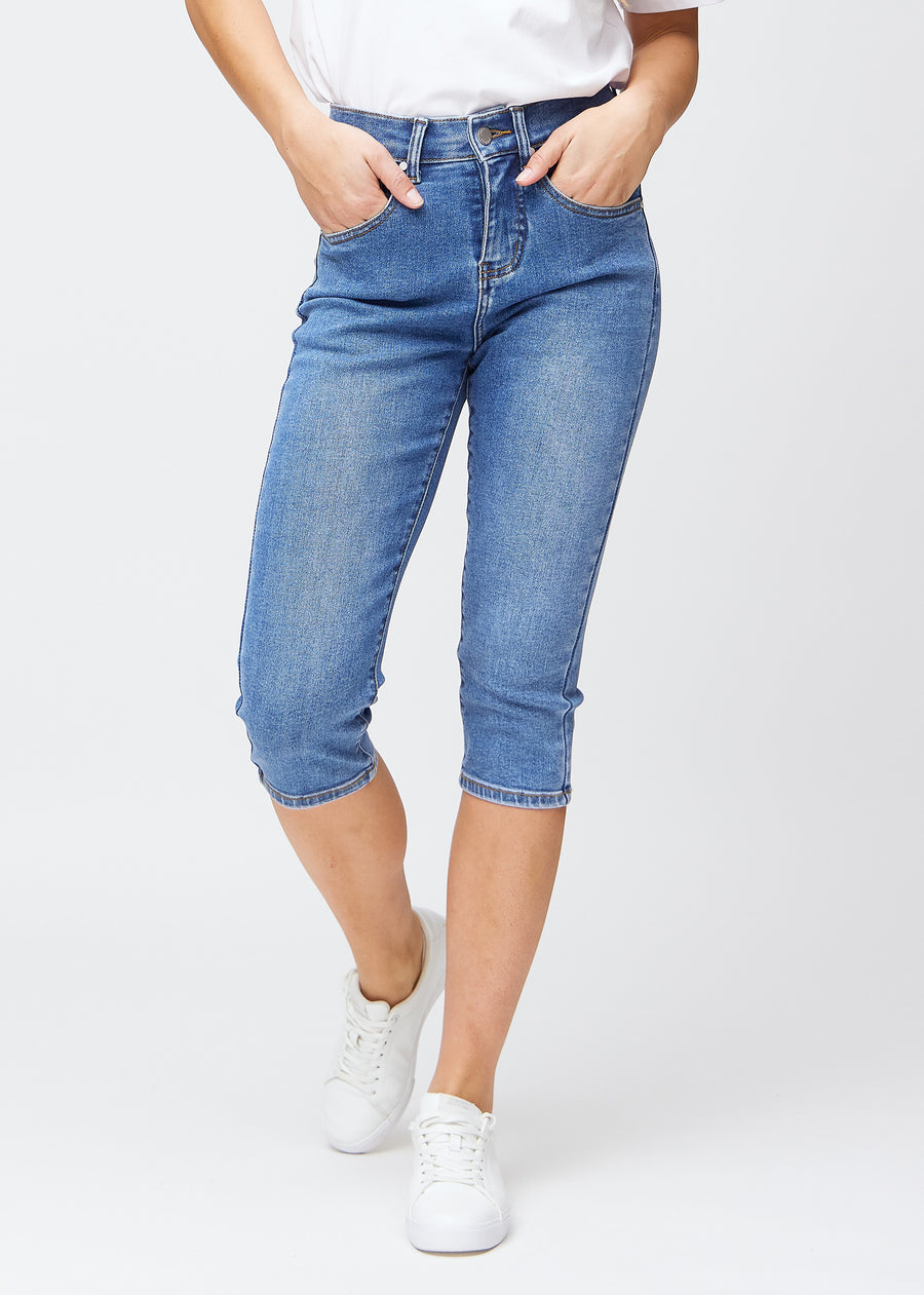 Slim-capris til kvinner i blå denim, fargen Rivers. Sett forfra på en modell, med figursydd passform til rett under kneet.