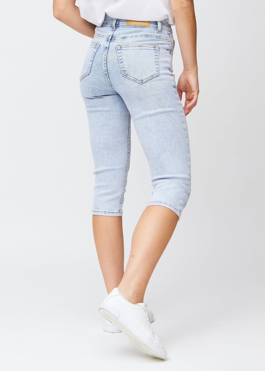 Slim-capris til kvinner i lyseblå denim, fargen Waves. Sett bakfra på en modell, med fokus på passform, lengde og baklommer.