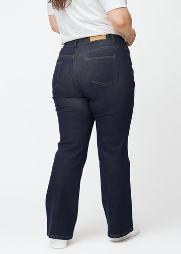Dyp mørkeblå denim jeans til kvinner i fargen Midnights sett bakfra på plus-size-modell.