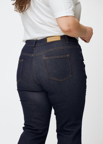 Dyp mørkeblå denim jeans til kvinner i fargen Midnights sett bakfra på nært hold på plus-size-modell.