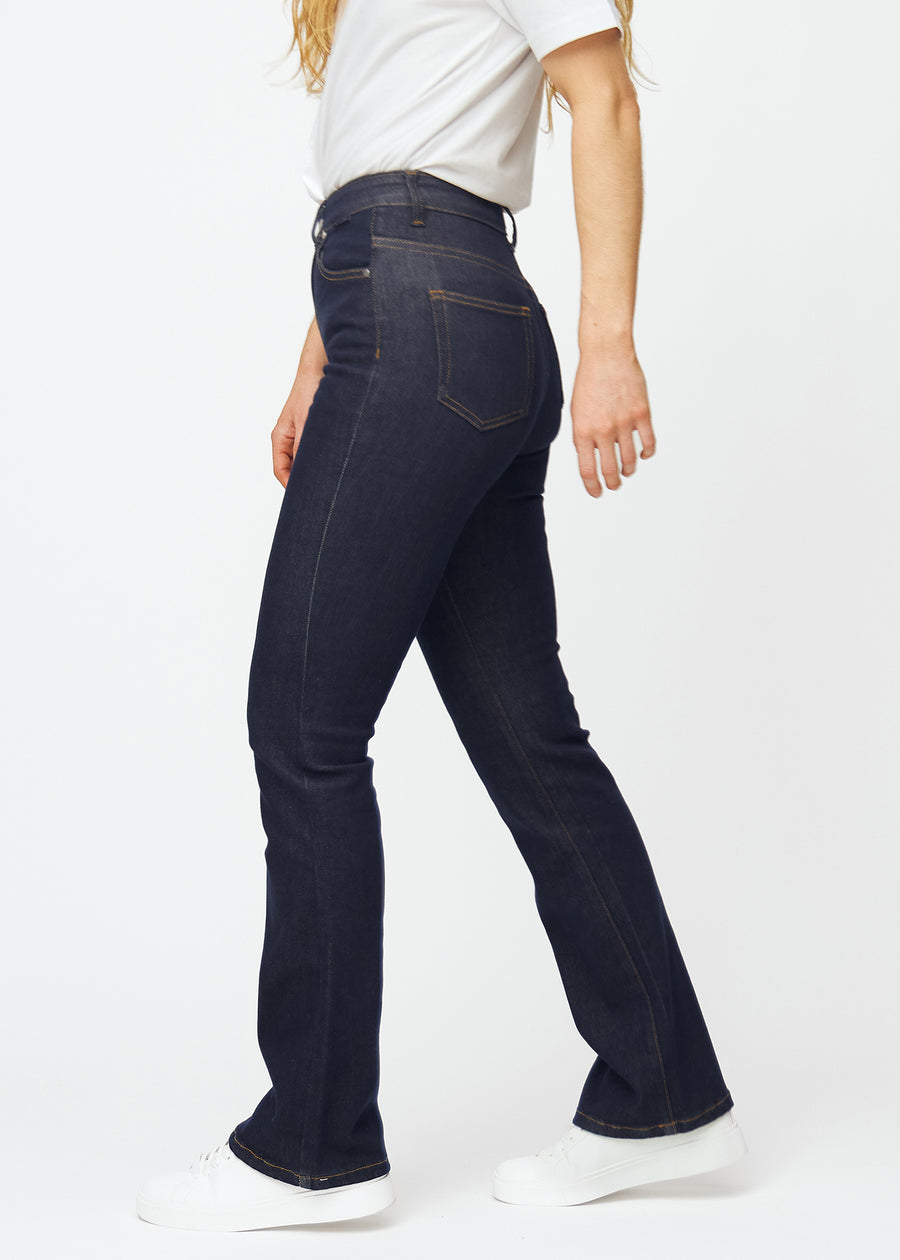 Dyp mørkeblå denim jeans til kvinner i fargen Midnights med bootcut-passform sett fra siden på modell.