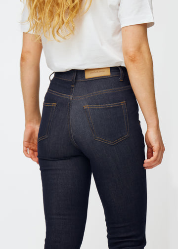 Dyp mørkeblå denim jeans til kvinner i fargen Midnights sett bakfra på nært hold for å vise passform og detaljer.