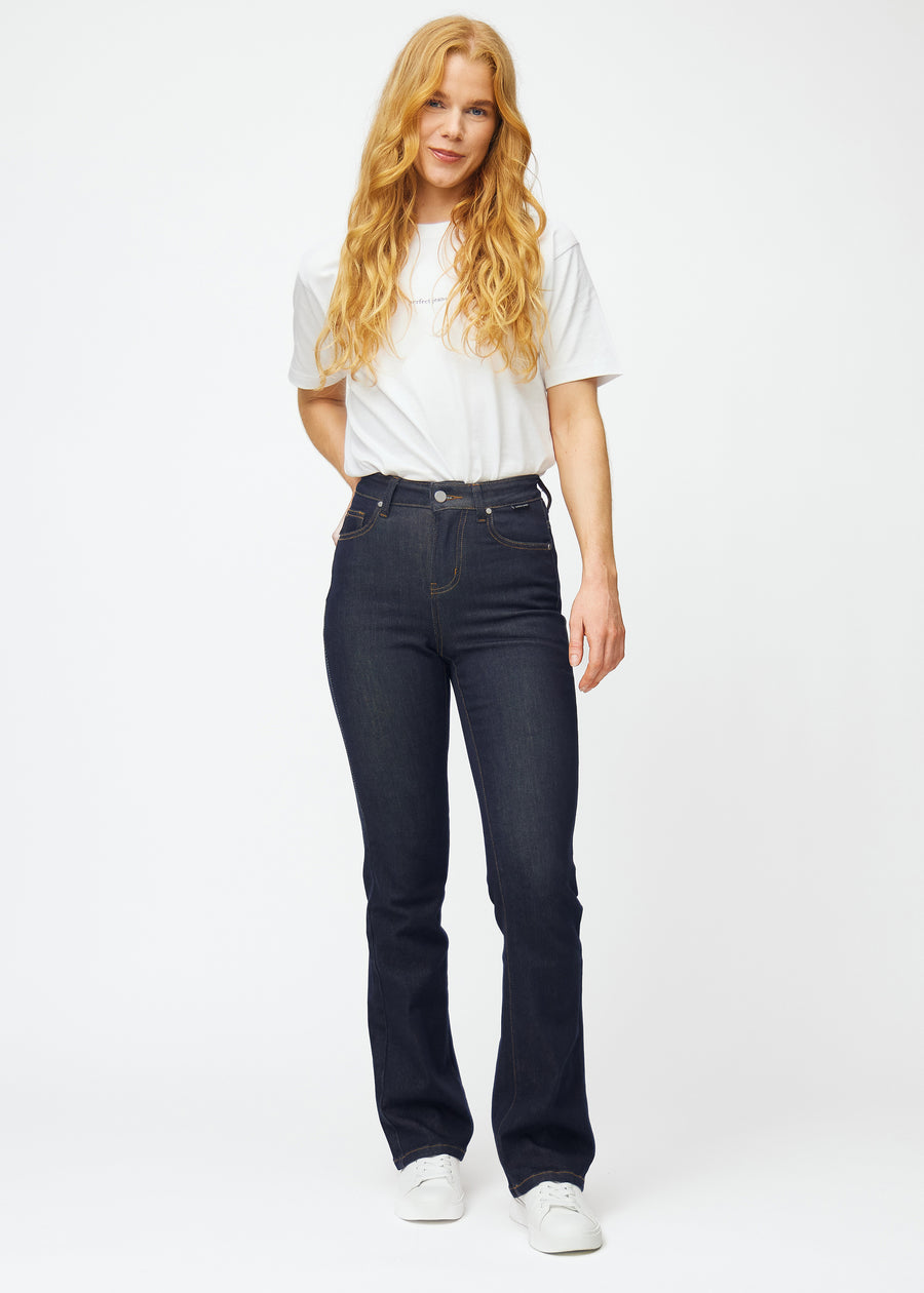 Fullt bilde av modell i dyp mørkeblå denim jeans til kvinner i fargen Midnights med bootcut-passform.