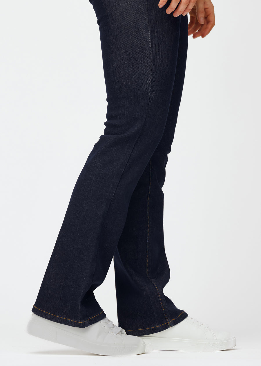 Dyp mørkeblå denim jeans til kvinner i fargen Midnights med bootcut-passform sett på nært hold ved anklene for å vise den lette slengen.