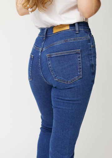Mørkeblå mid-rise bootcut-jeans i fargen Oceans. Nærbilde bakfra på en modell for å vise detaljene.