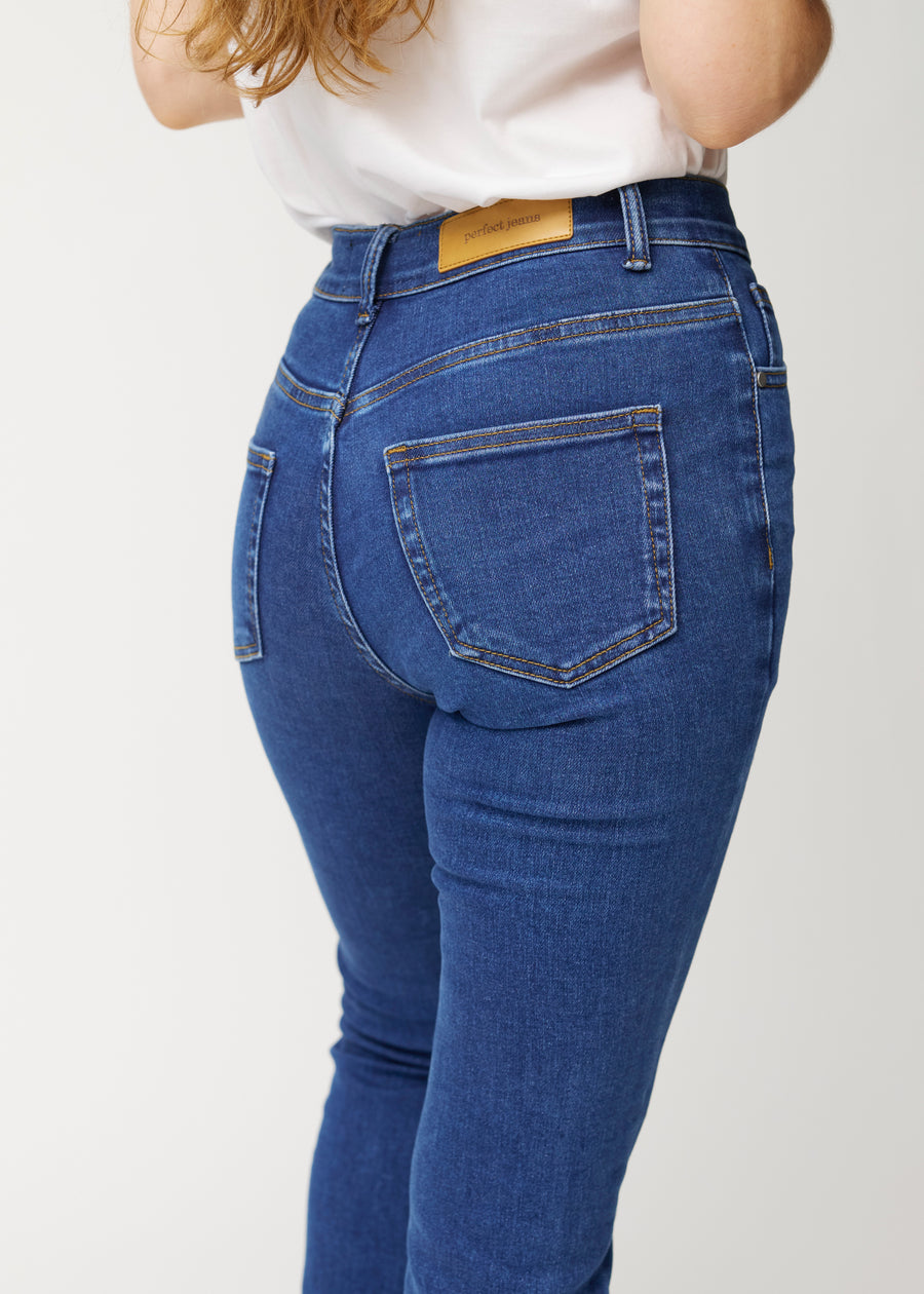 Mørkeblå mid-rise bootcut-jeans i fargen Oceans. Nærbilde bakfra på en modell for å vise detaljene.