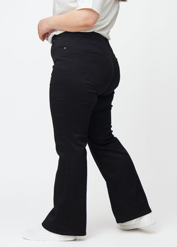 Sorte mid-rise bootcut jeans set fra siden på en plus-size model.