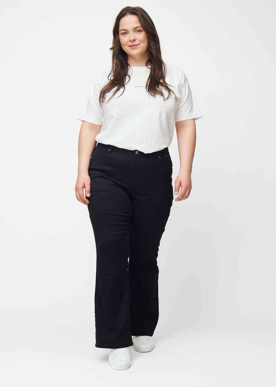 Fuldt billede af en plus-size model i sorte mid-rise bootcut jeans.
