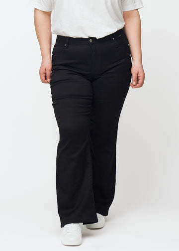Sorte mid-rise bootcut jeans, modelnavn Ravens, som sidder tæt fra hofte til lår og har et let svaj forneden, på en plus-size model, set forfra.