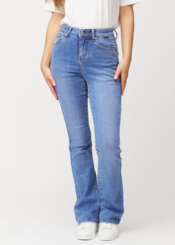 Blå mid-rise bootcut-jeans i fargen Rivers. Sett forfra på en modell, med tettsittende passform over hofter og lår og lett utsving nederst.