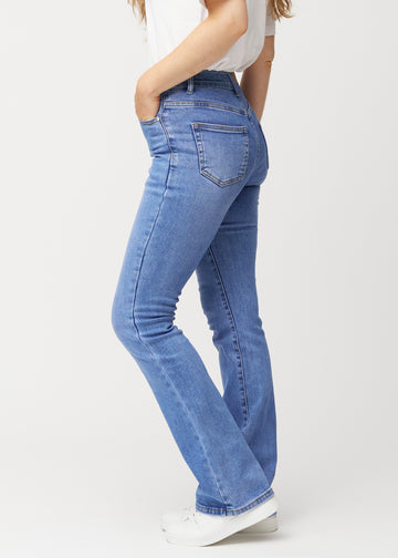 Blå mid-rise bootcut-jeans i fargen Rivers. Sett fra siden på en modell.