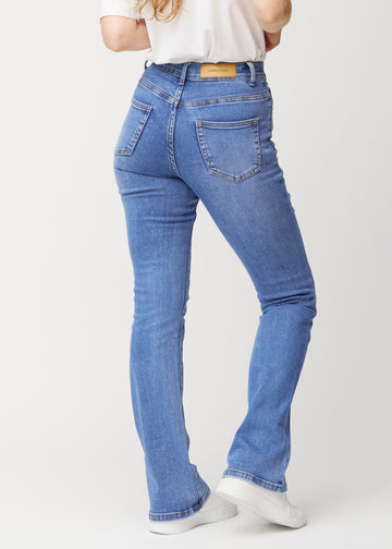 Blå mid-rise bootcut-jeans i fargen Rivers. Sett bakfra på en modell, slik at hele passformen vises.