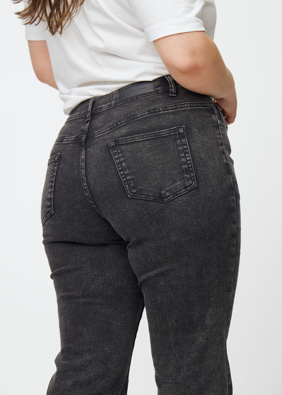 Mørkegrå mid-rise bootcut-jeans i fargen Shadows. Nærbilde bakfra på en plus size-modell for å vise detaljene.