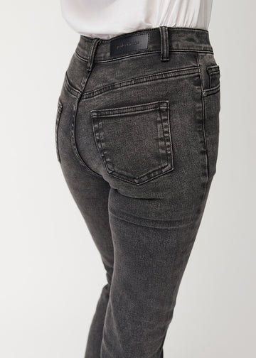 Mørkegrå mid-rise bootcut-jeans i fargen Shadows. Nærbilde bakfra på en modell for å vise detaljene.