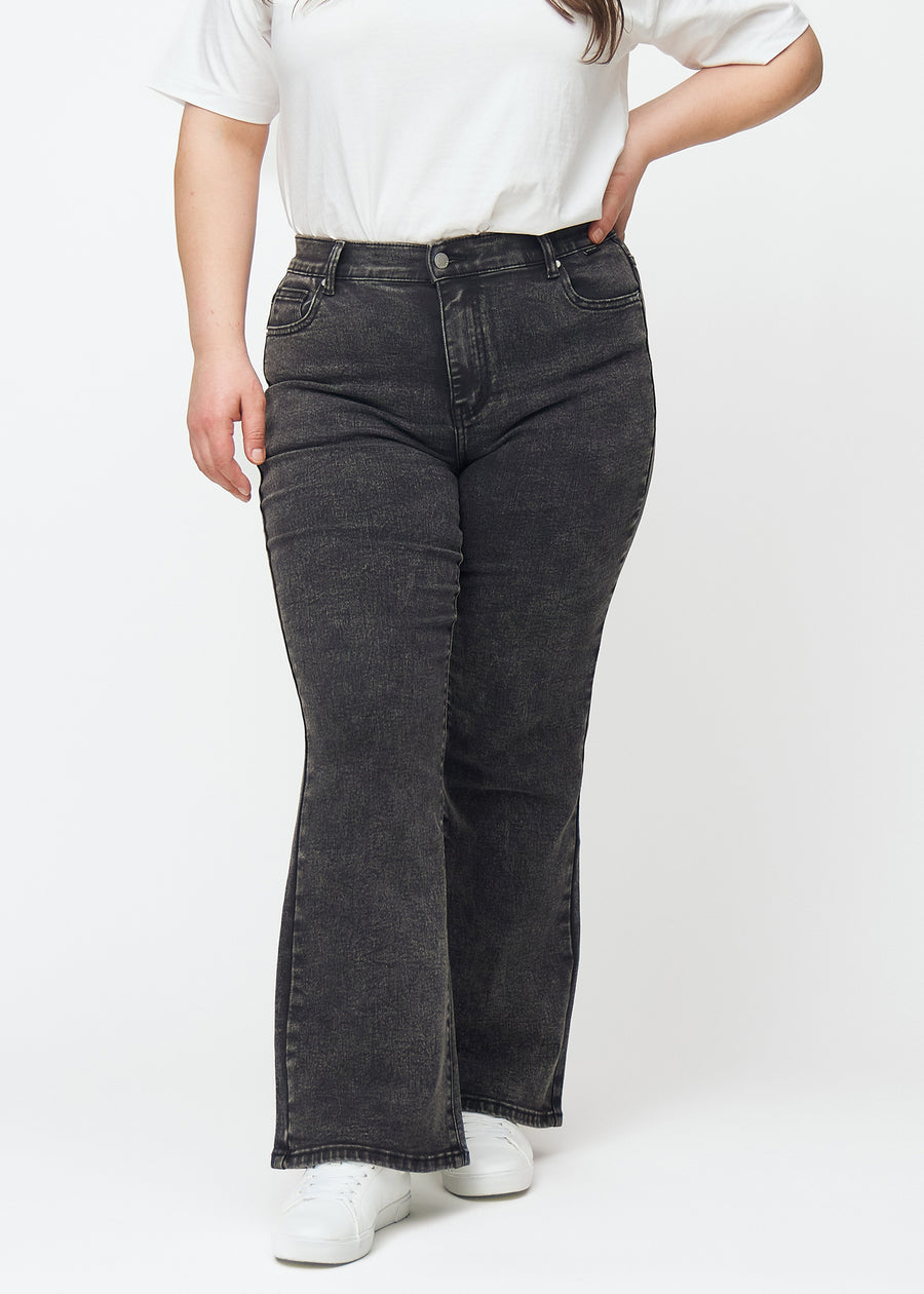 Mørkegrå mid-rise bootcut-jeans i fargen Shadows. Sett forfra på en plus size-modell, med tettsittende passform over hofter og lår og lett utsving nederst.