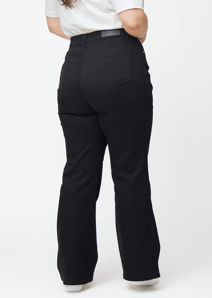 Svarte høytaljede bootcut jeans sett bakfra på en plus-size-modell, så man kan se hele produktet.