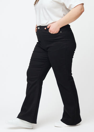 Svarte høytaljede bootcut jeans sett fra siden på en plus-size-modell.