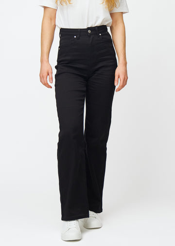 Svarte høytlivede jeans av modellen Ravens, som sitter til i midjen og har en løs passform med vidde nedover, sett forfra.