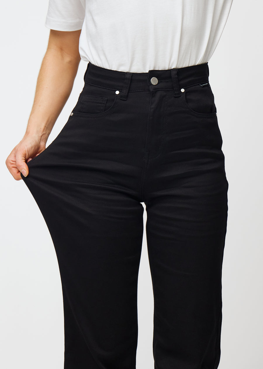 Modellen strekker jeansene ved låret for å vise stretch.