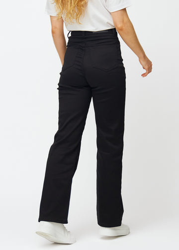 Svarte høytlivede jeans, som sitter til i midjen og har en løs passform med vidde nedover, sett bakfra for å vise hele produktet.