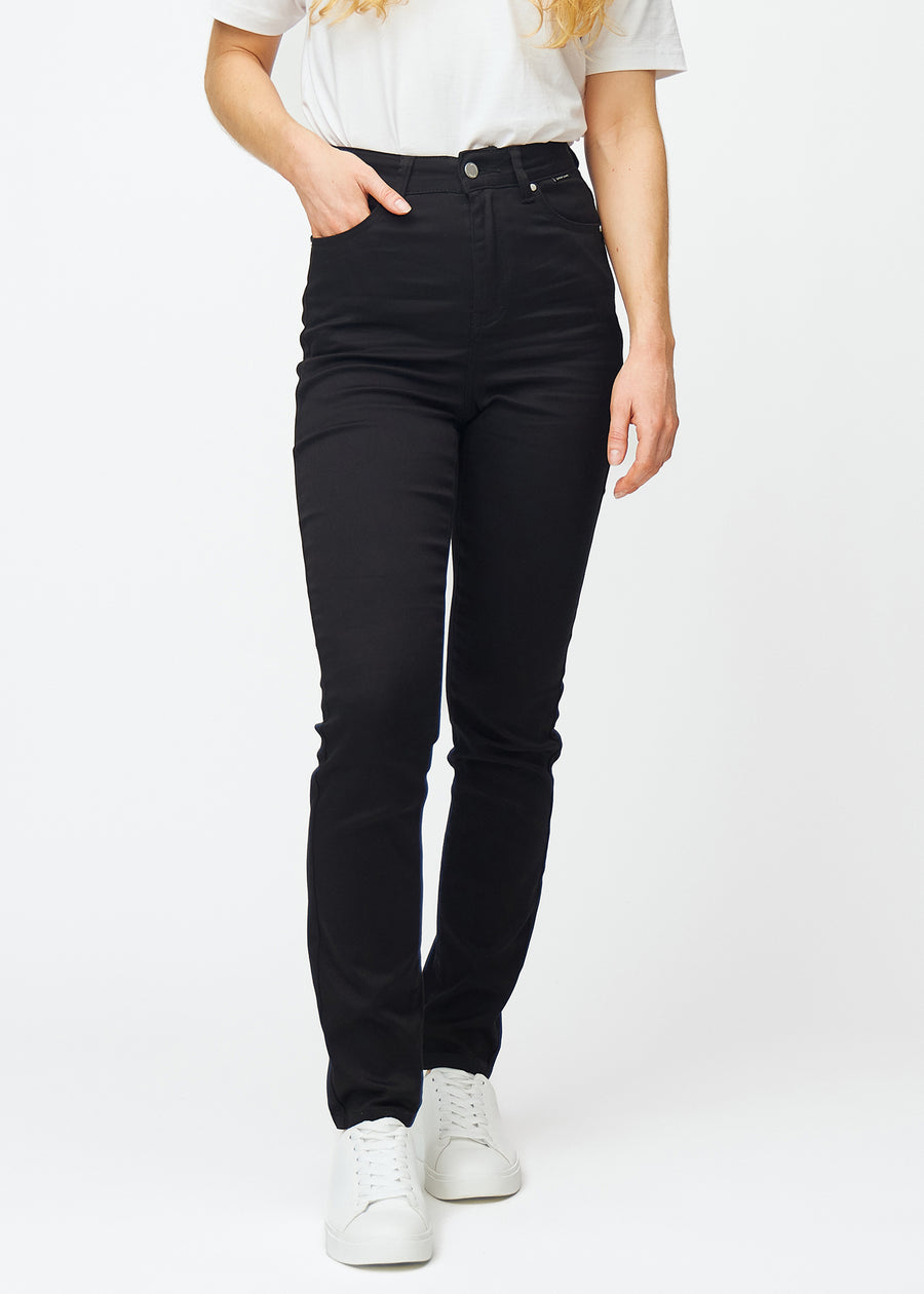 Svarte høytaljede slim jeans, modellnavn Ravens, som sitter tett til benet, men litt løsere ved ankelen, sett forfra.
