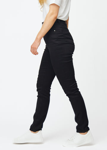 Svarte høytaljede slim jeans sett fra siden på modell.