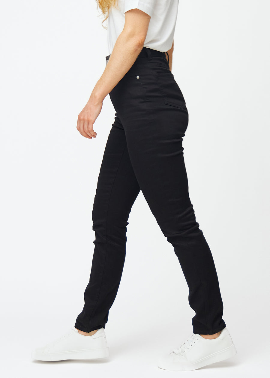 Svarte høytaljede slim jeans sett fra siden på modell.