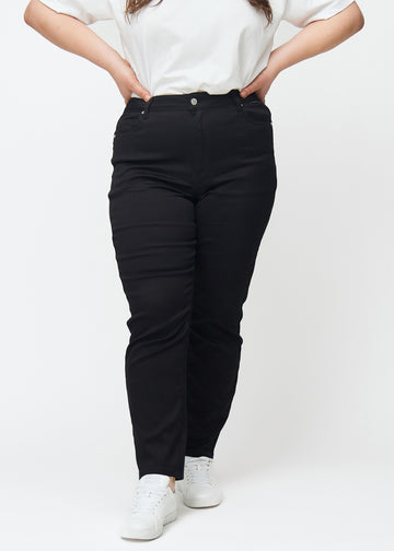 Svarte høytaljede slim jeans, modellnavn Ravens, som sitter tett til benet, men litt løsere ved ankelen, på en plus-size-modell, sett forfra.