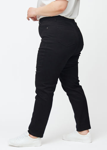 Svarte høytaljede slim jeans sett fra siden på en plus-size-modell.
