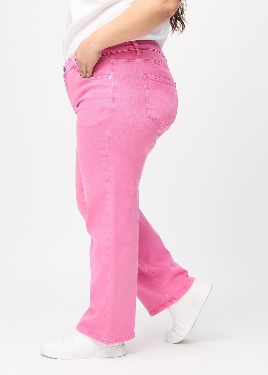 Loose-jeans til kvinner i lyserosa, fargen Flamingos. Sett fra siden på en plus size-modell, med synlig løs passform.