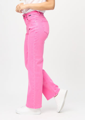 Loose-jeans til kvinner i lyserosa, fargen Flamingos. Sett fra siden på en modell, med synlig løs passform.