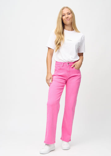 Loose-jeans til kvinner i lyserosa, fargen Flamingos. Helhetsbilde av en modell med løstsittende jeans.