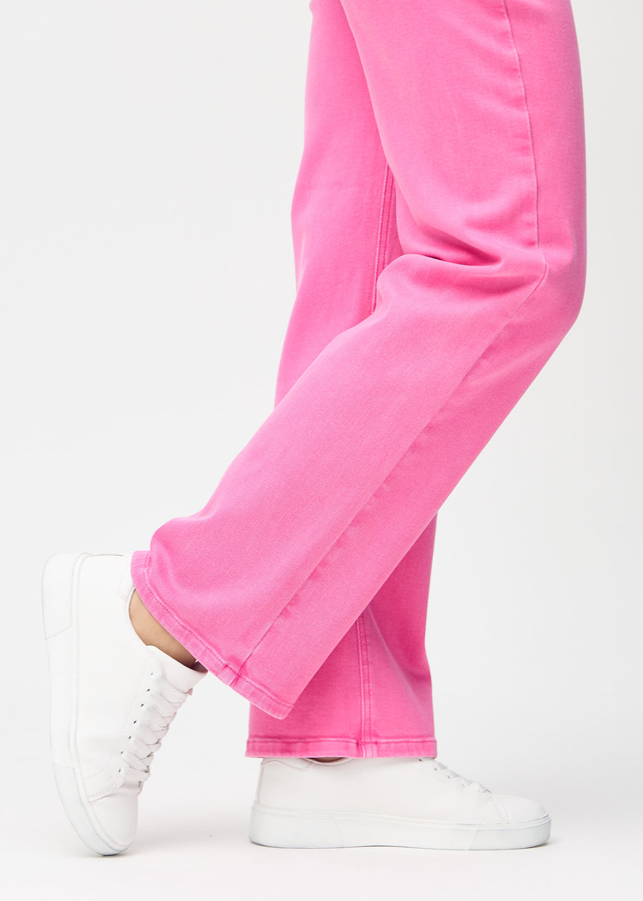Loose-jeans til kvinner i lyserosa, fargen Flamingos. Nærbilde ved anklene på en modell, som viser de vide benavslutningene.